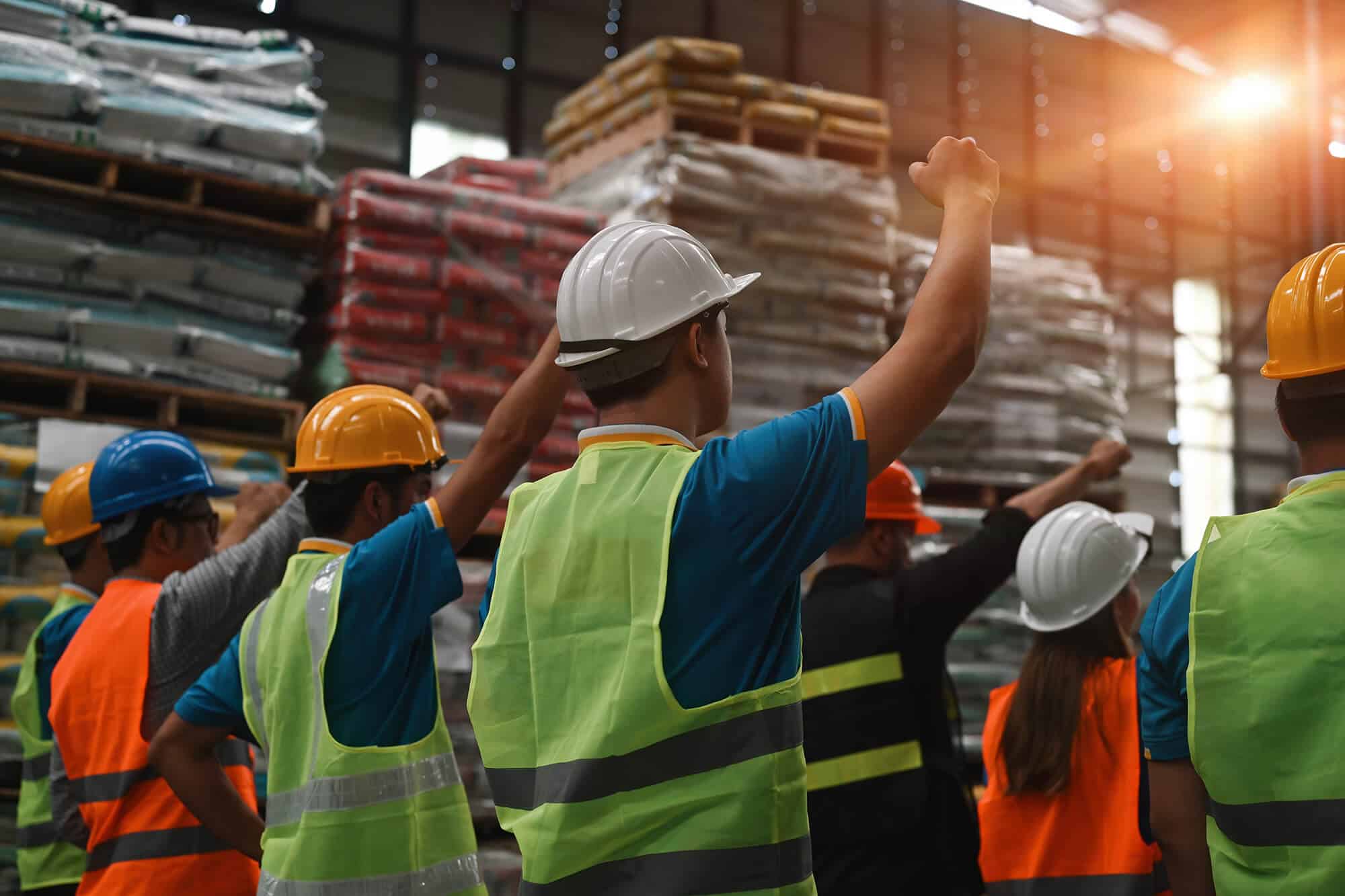 Manufacturing employees raising their hands