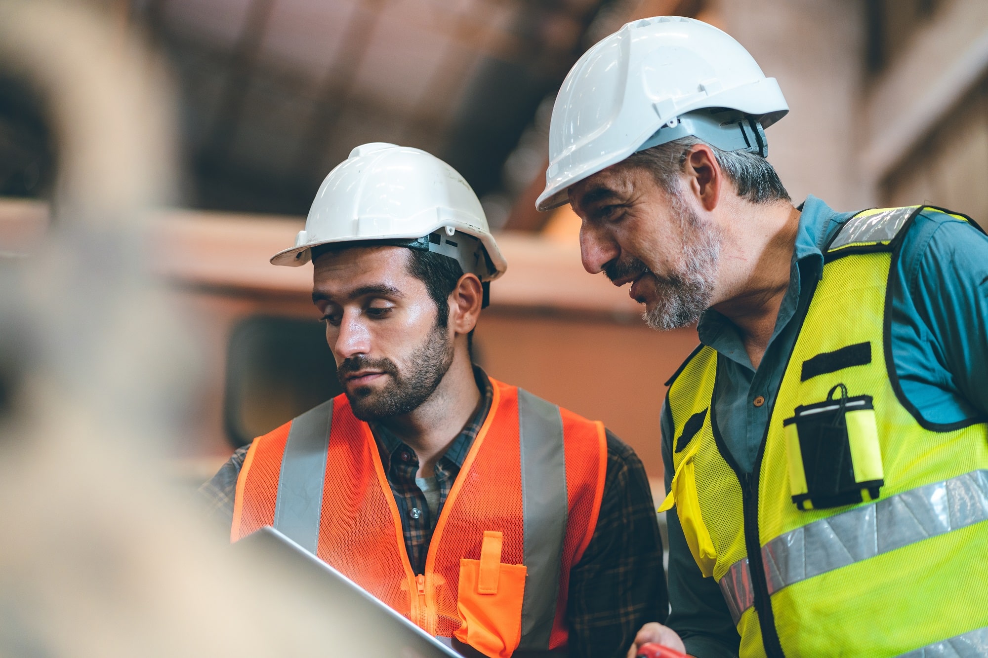 foreman in safety helmet hard hat using blueprint in digital tablet working