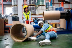 Industrial Worker Receiving Assistance After Factory Accident in Safety Gear