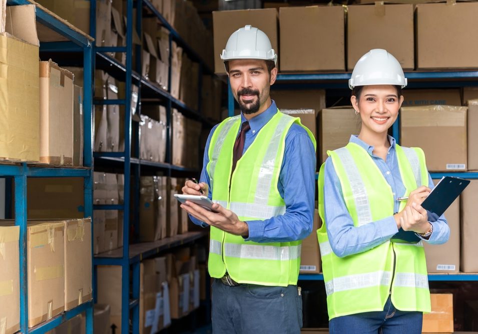 Senior employer working in the warehouse with his new employee Senior employer working in the warehouse with his new employee