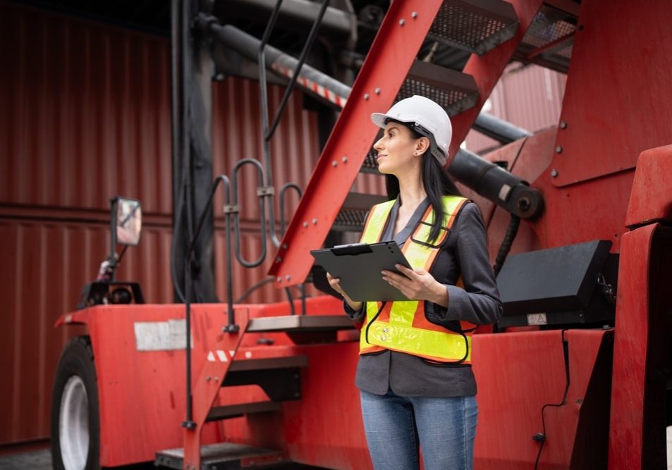 Caucasian woman supervisor engineer worker working with truck at container site