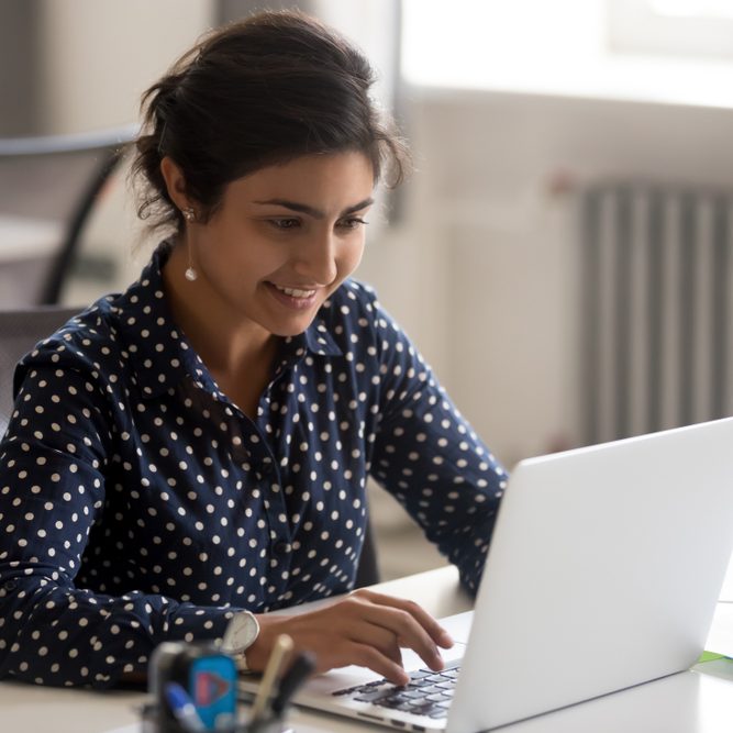 Smiling female employee doing interview using the laptop