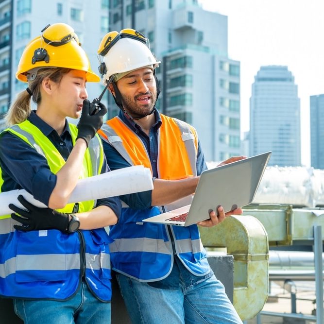Professional Asian man and woman teamwork engineer and foreman using laptop working outdoor at construction site Professional Asian man and woman teamwork engineer and foreman using laptop working outdoor at construction site