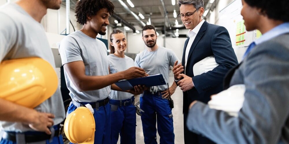 factory workers going through production reports in industrial plant