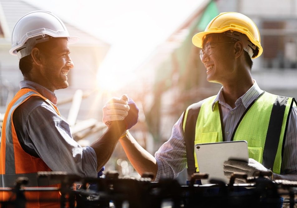 Manufacturing employees greeting each other Manufacturing employees greeting each other