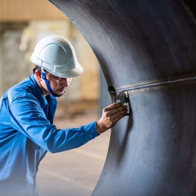 QC Technician inspector using welding gauge inspection butted weld on plate steel structure in industry fabrication factory