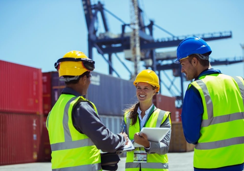 workers talking near cargo containers workers talking near cargo containers