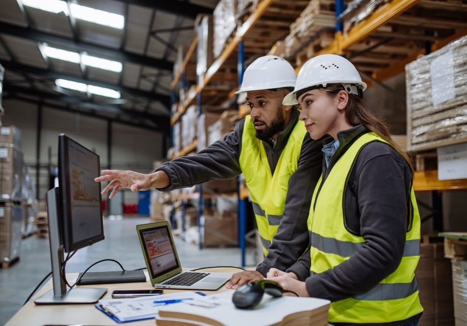 Warehouse manager talking with logistics employee in warehouse