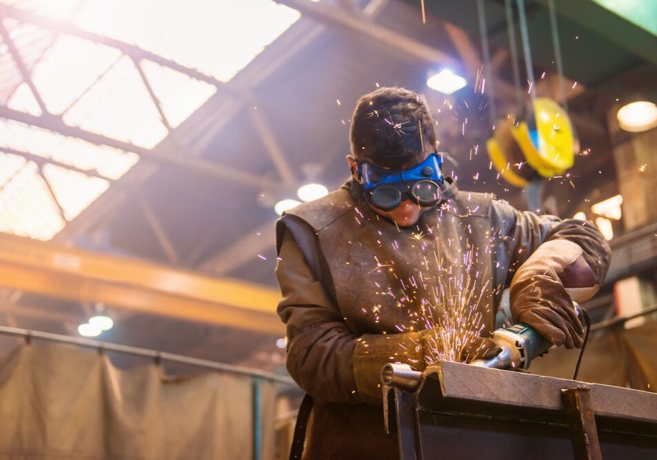 Young,Man,With,Protective,Goggles,Welding,In,A,Factory Young man with protective goggles welding in a factory